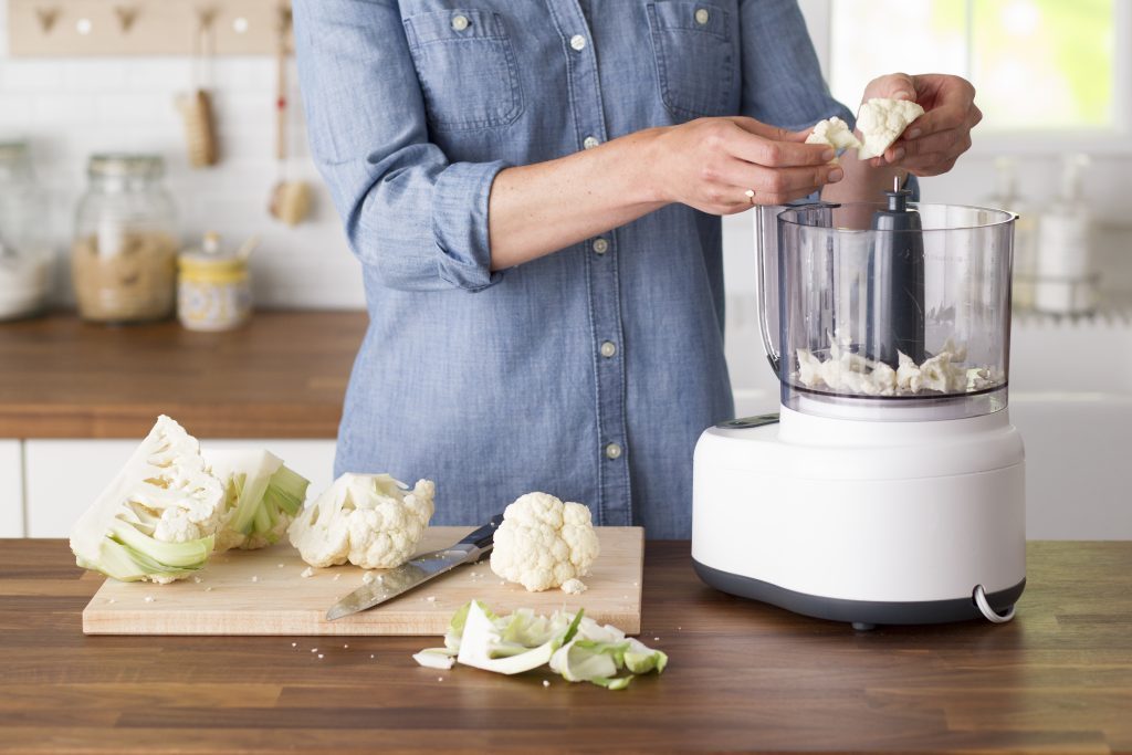 Person pulling pieces of cauliflower apart to place into a blender