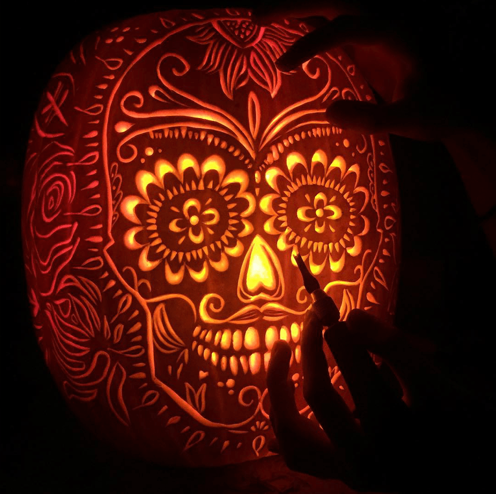 Intricately carved Day of the Dead skull on a pumpkin