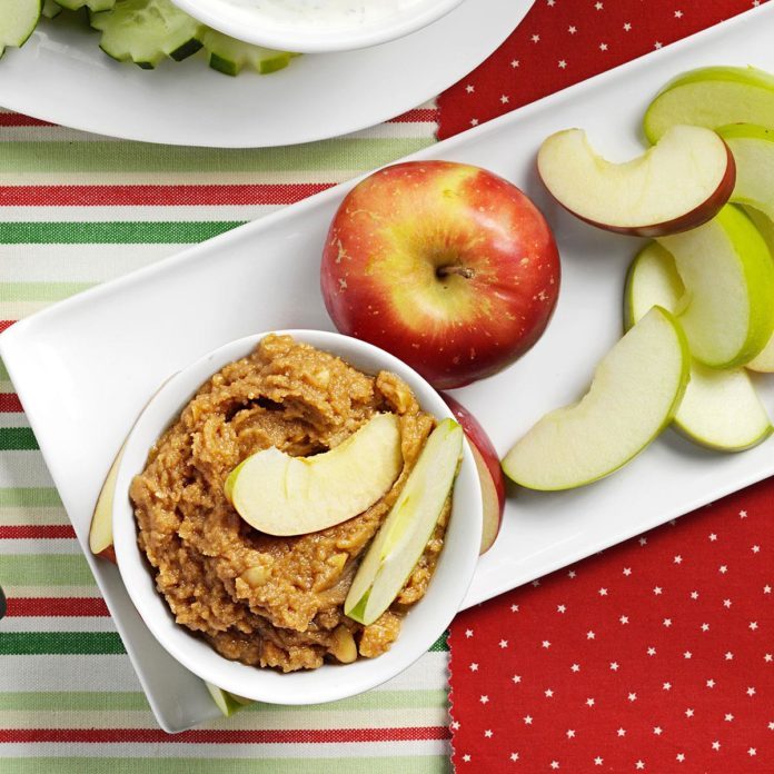 A plate with an apple appetizer of sliced apples and crunchy peanut butter apple dip