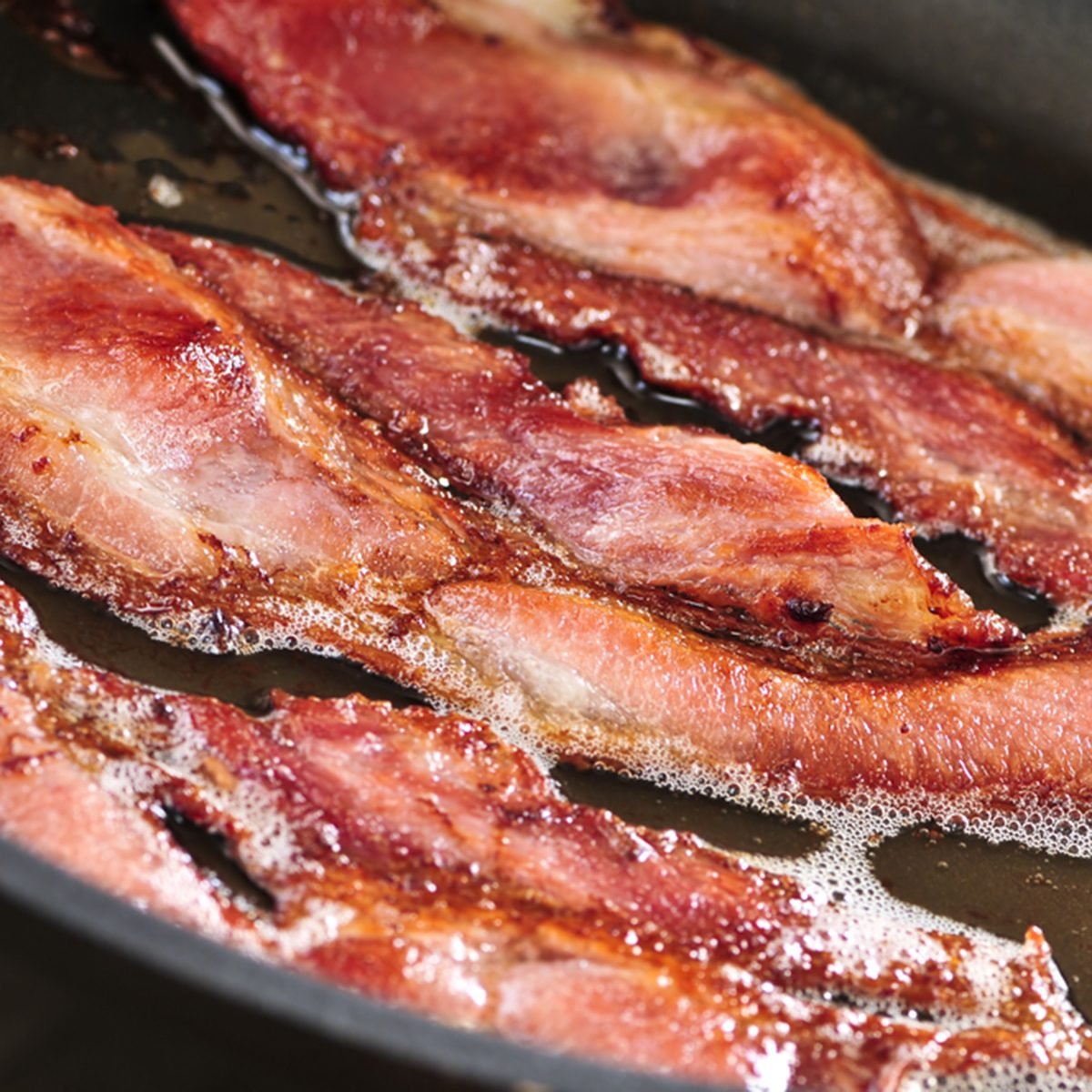 Bacon strips sizzling on a frying pan; Shutterstock ID 29677456; Job (TFH, TOH, RD, BNB, CWM, CM): Taste Recipes