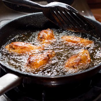 Chicken frying in a pan.