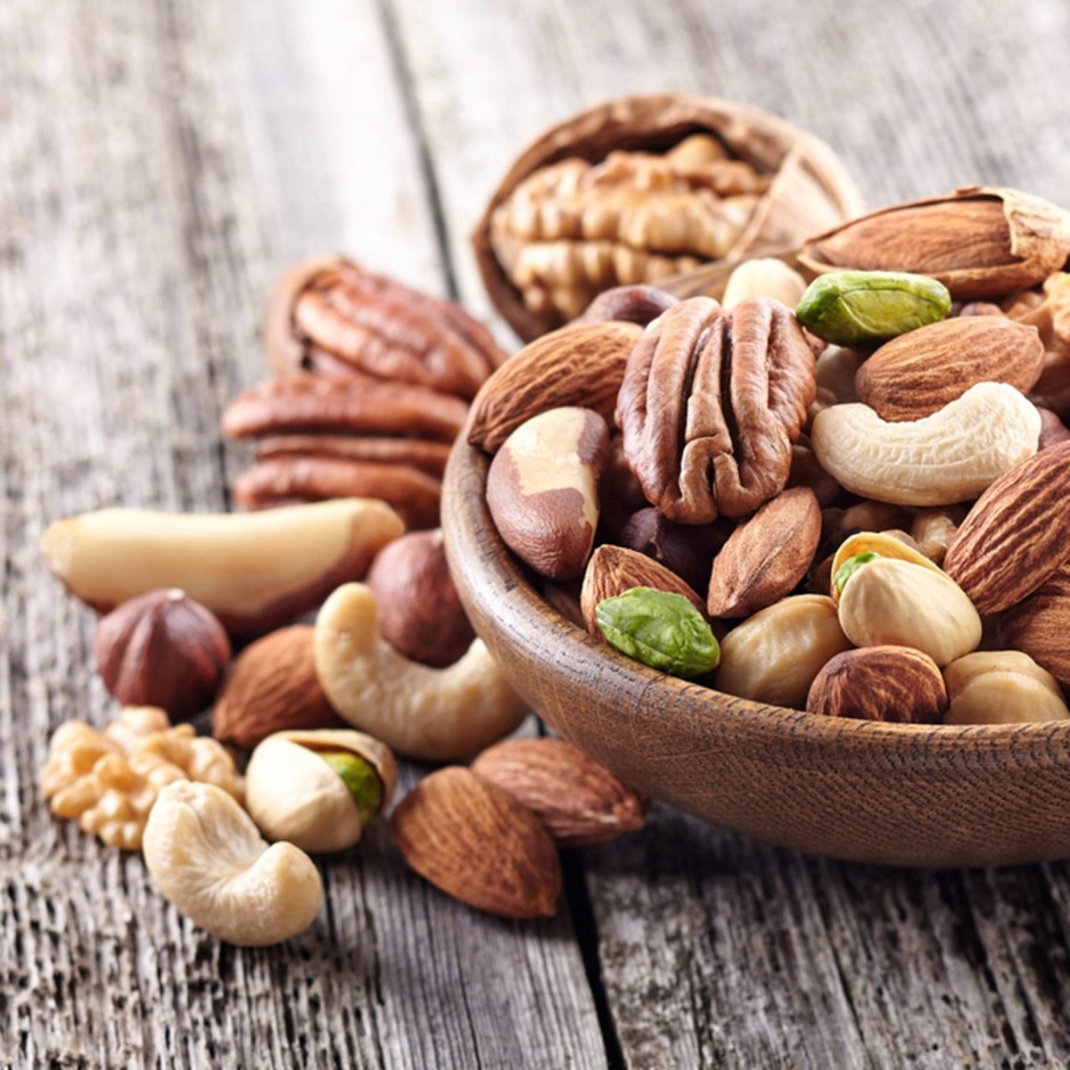 Nuts mix in a wooden plate; Shutterstock ID 355672364