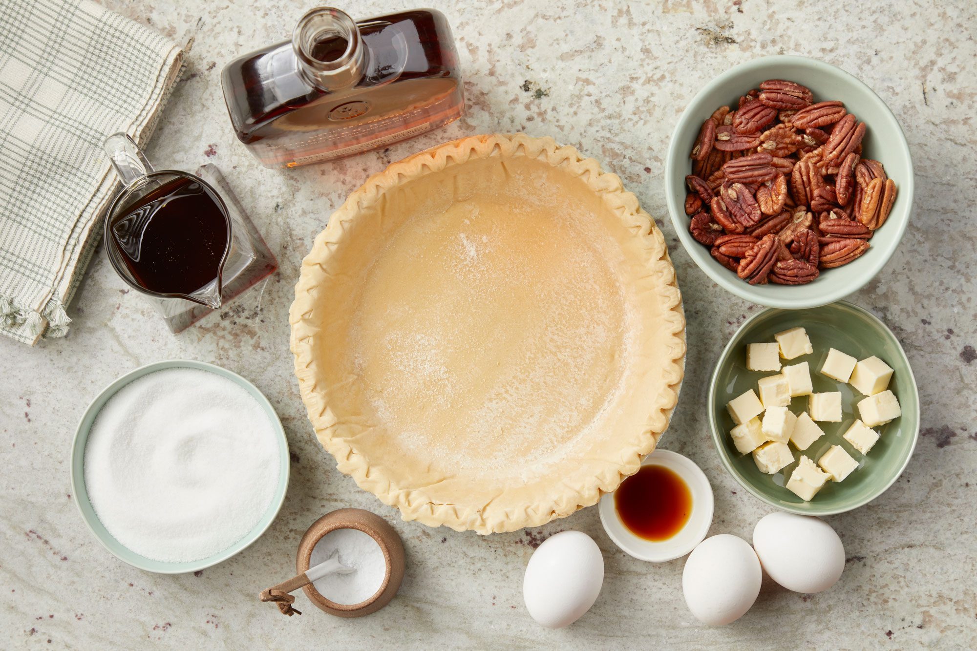 Overhead shot of all the ingredients for Bourbon Pecan Pie; marble background;