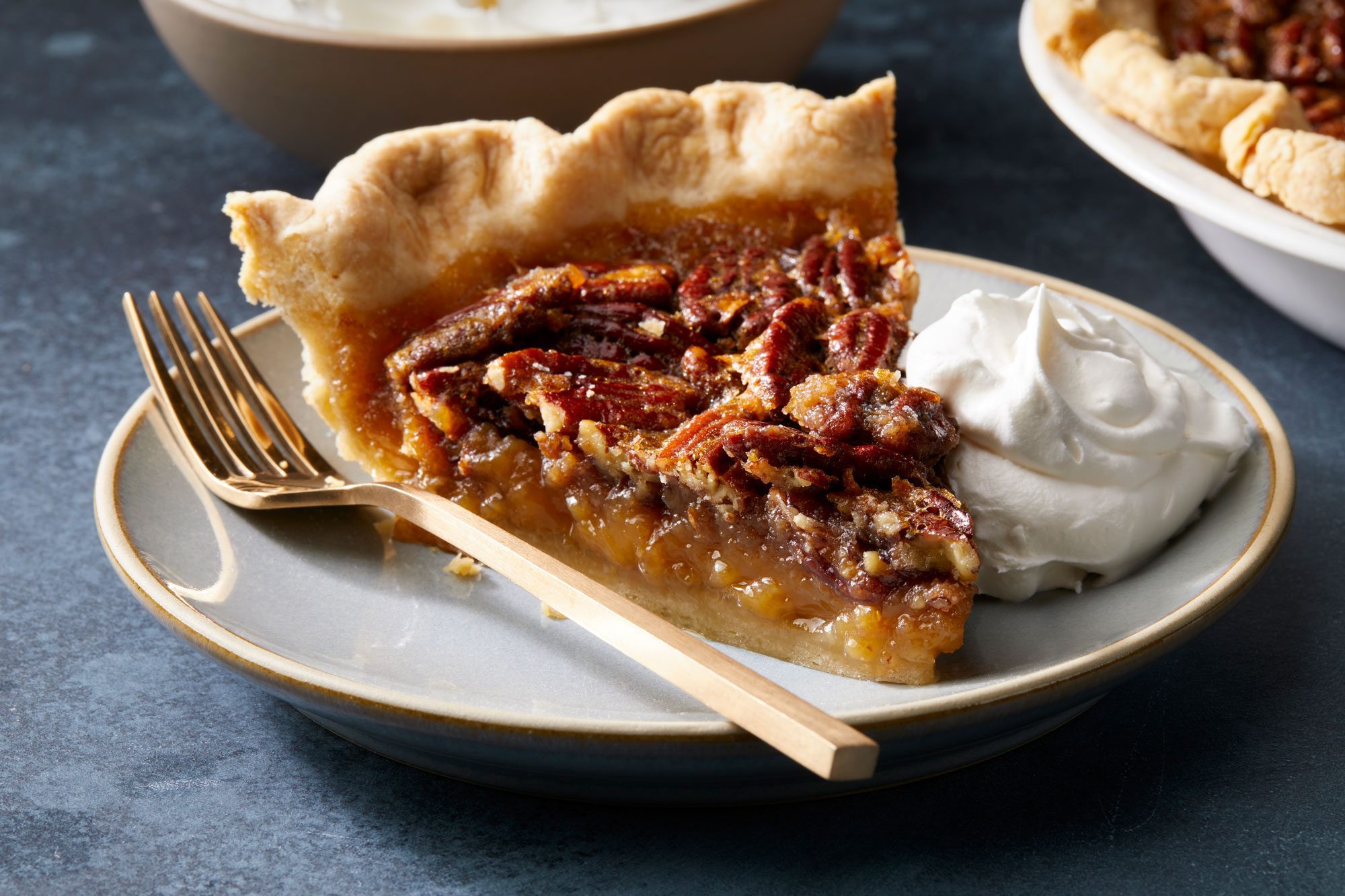 3/4th shot of Bourbon Pecan Pie served in a plate with fork; dark background;