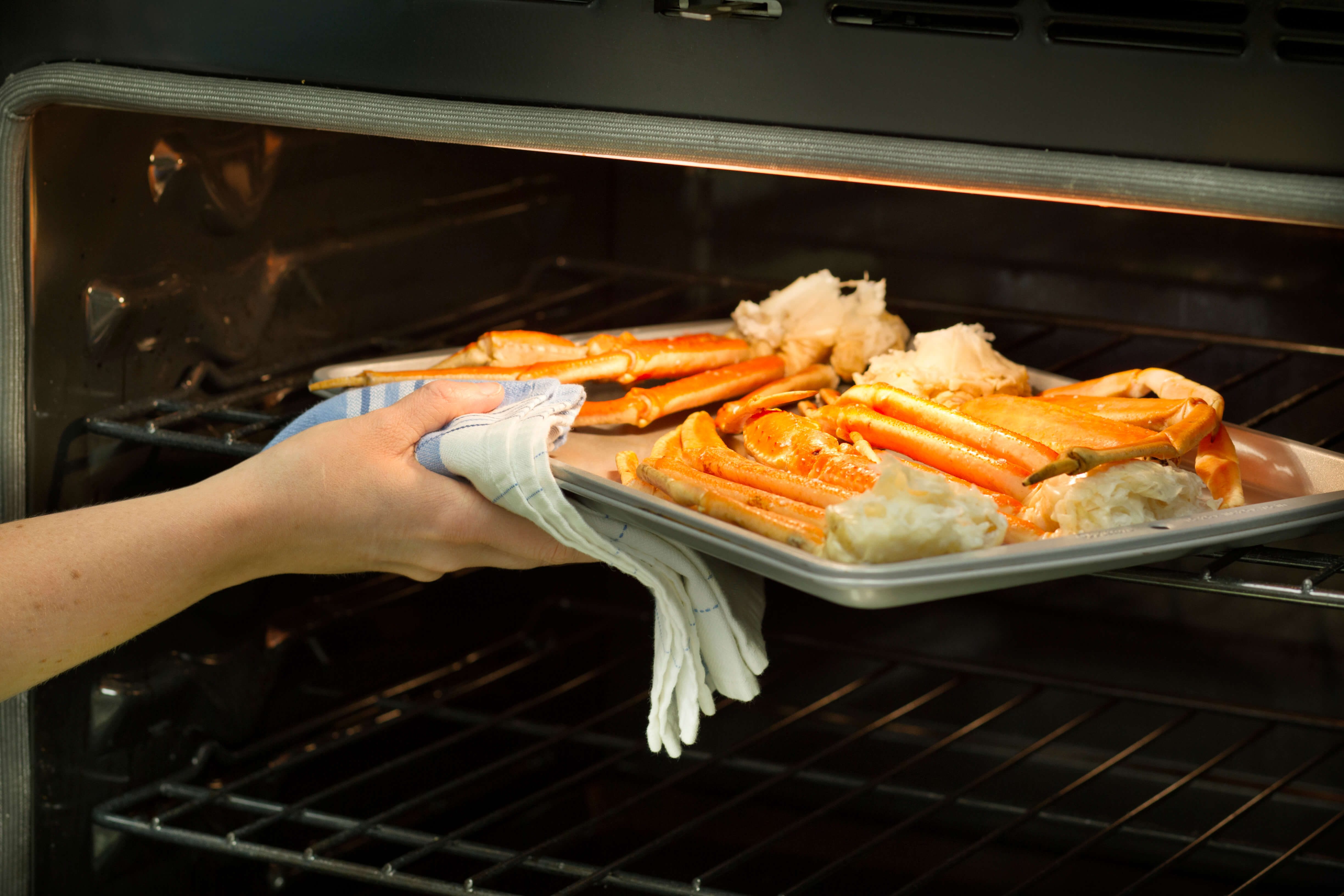 Crab legs on a baking sheet in an oven