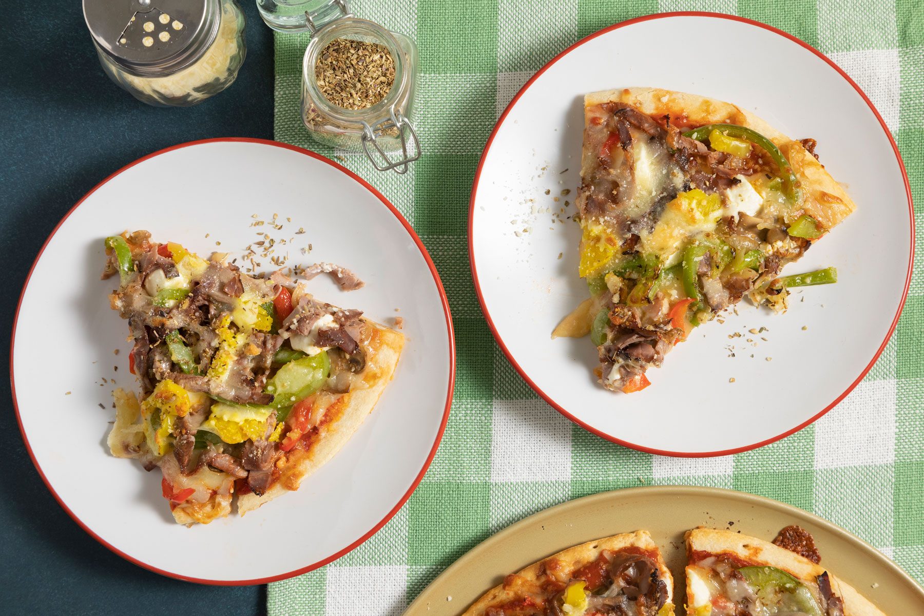 Slices of Philly Cheesesteak Pizza in small plates