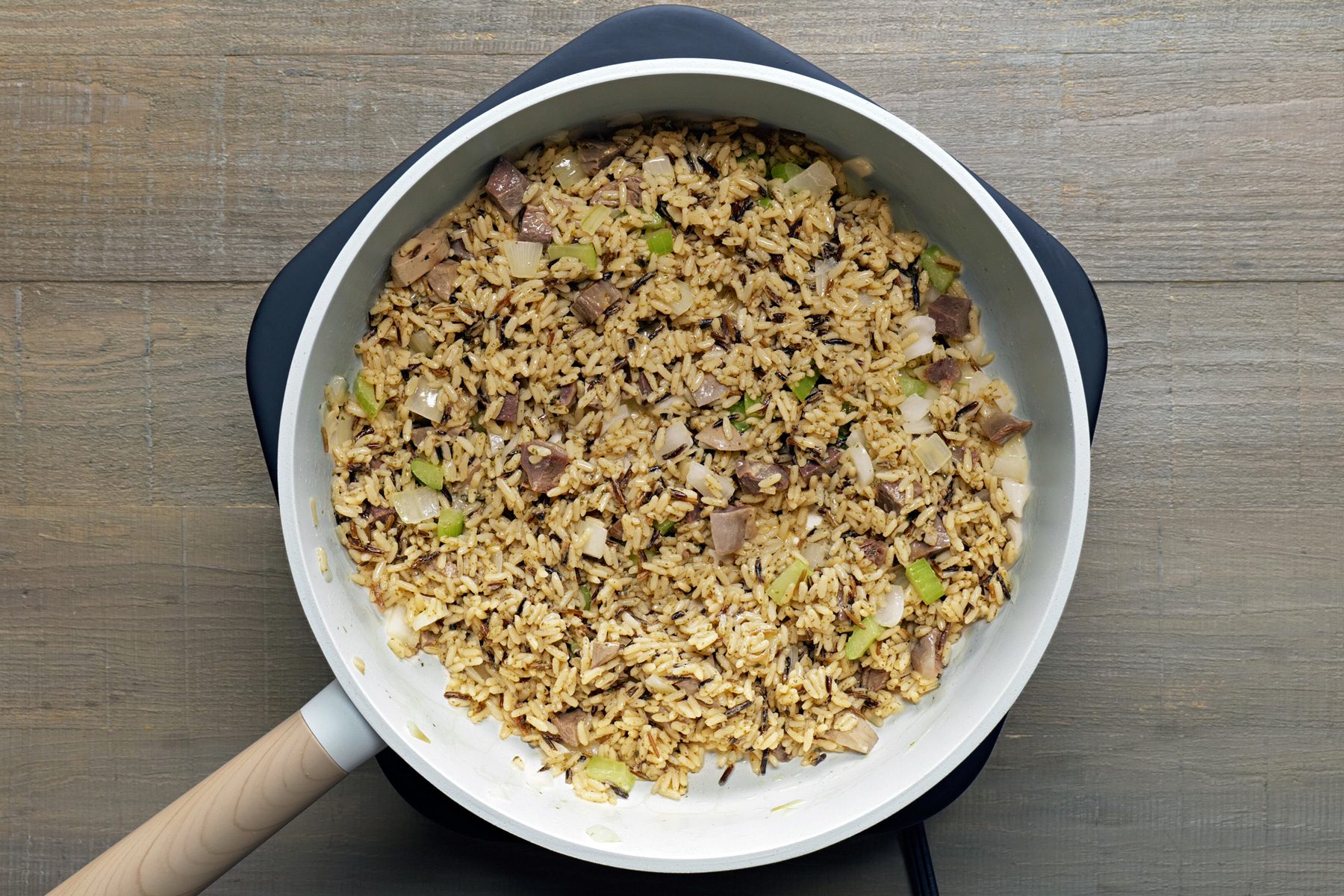 Mix the onions and celery into the cooked rice along with the stuffing mix, chicken broth and reserved giblets.