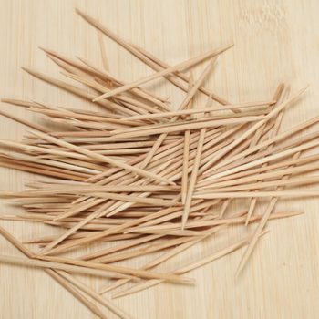 many wooden toothpicks on wooden table background