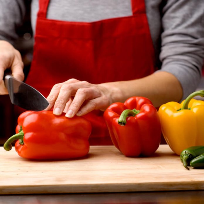 woman slicing fresh bell peppers