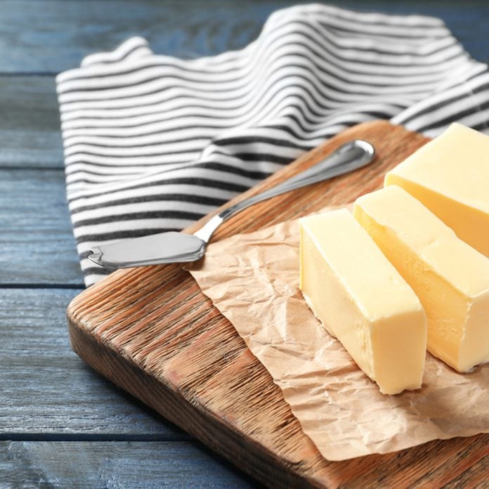 Cut block of butter on wooden board