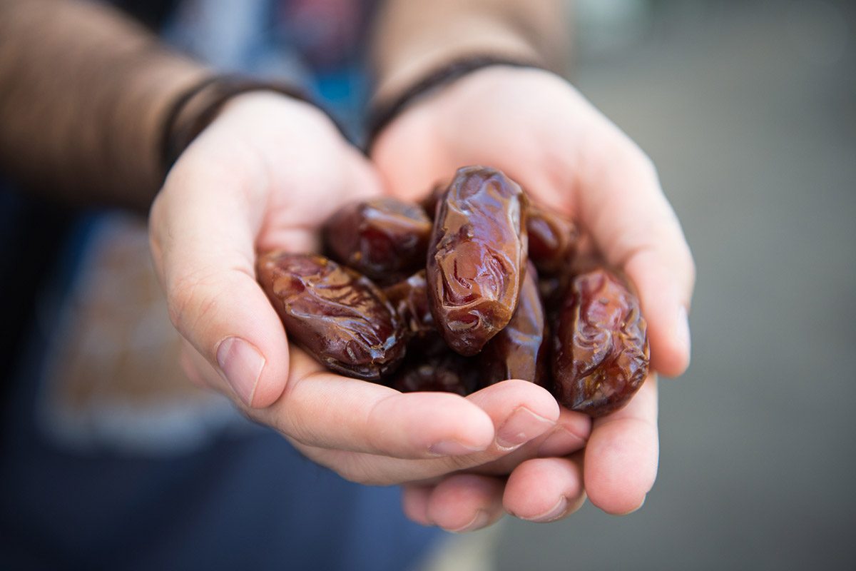 Hands holding Middle Eastern dates