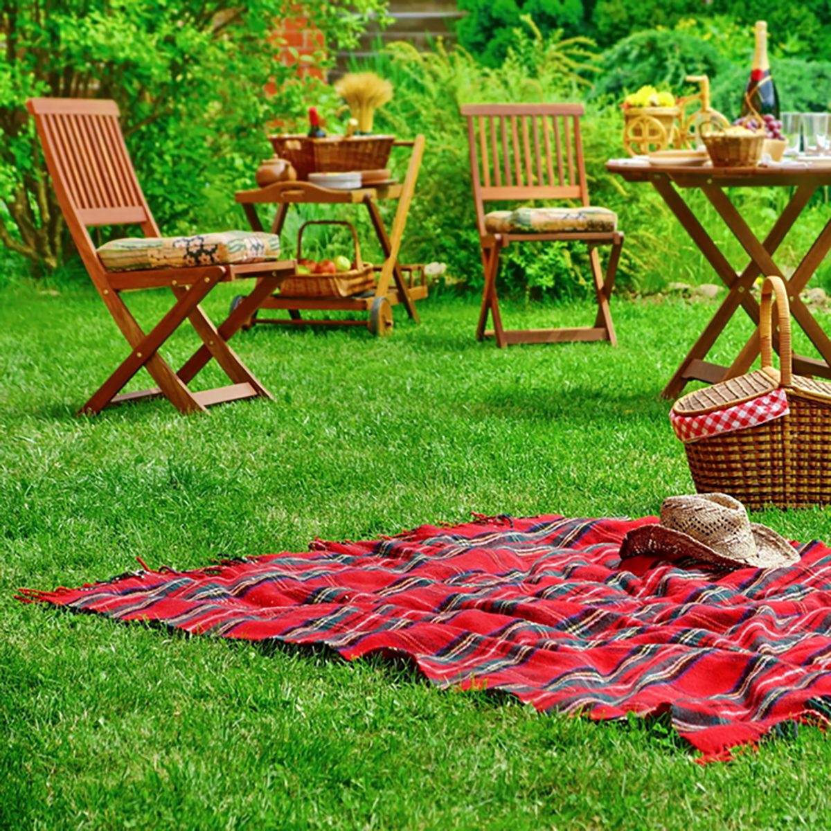 Closeup Of Red Picnic Blanket With Cowboy Straw Hat And Basket Or Hamper