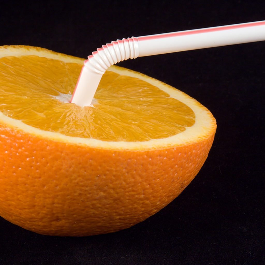 Orange half with straw inserted, on a black background.; Shutterstock ID 2434912; Job (TFH, TOH, RD, BNB, CWM, CM): Taste of Home