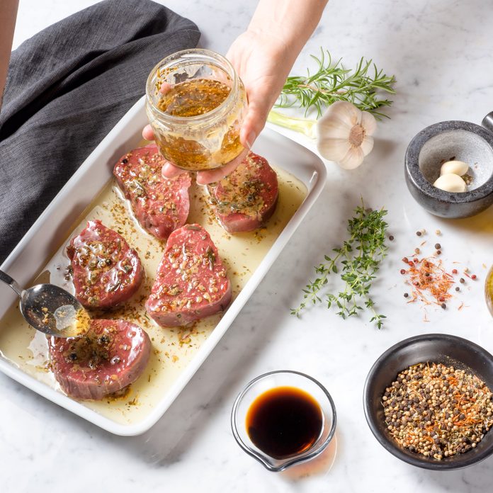 hands marinading a steak