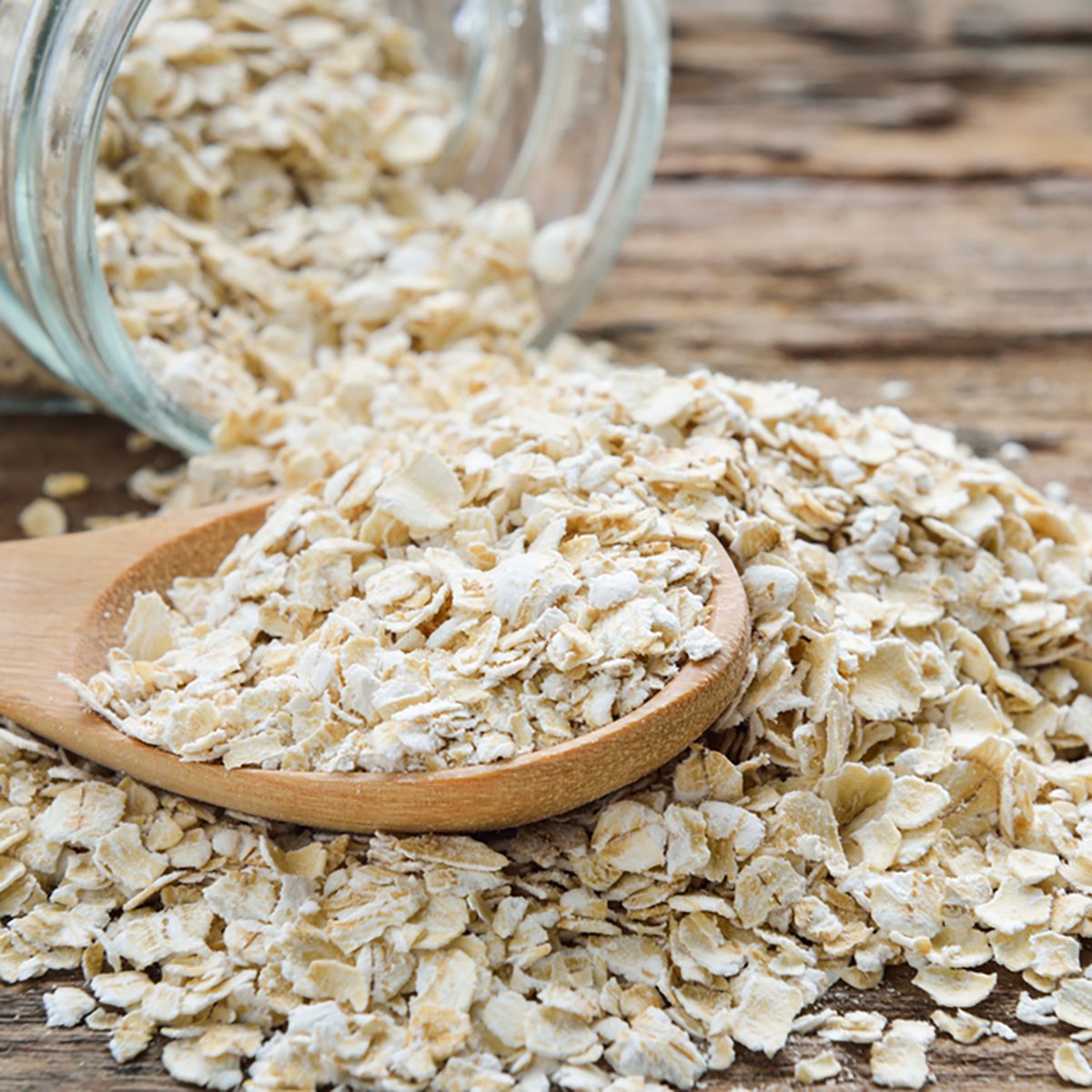 Dry rolled oat flakes oatmeal on old wooden table