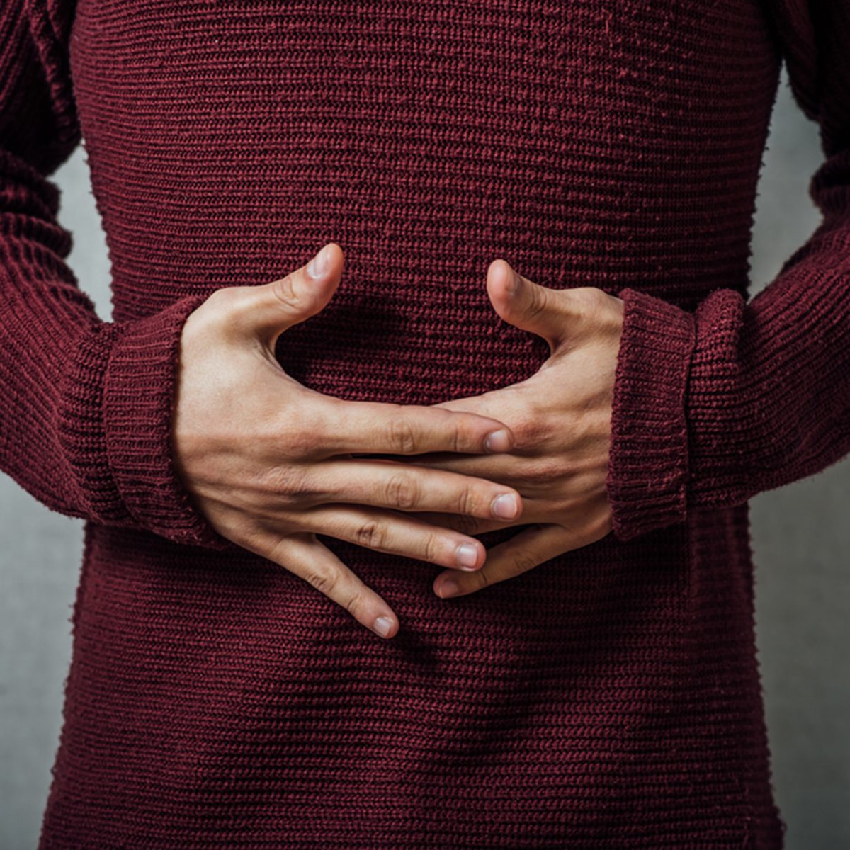 man holding his stomach in pain or indigestion