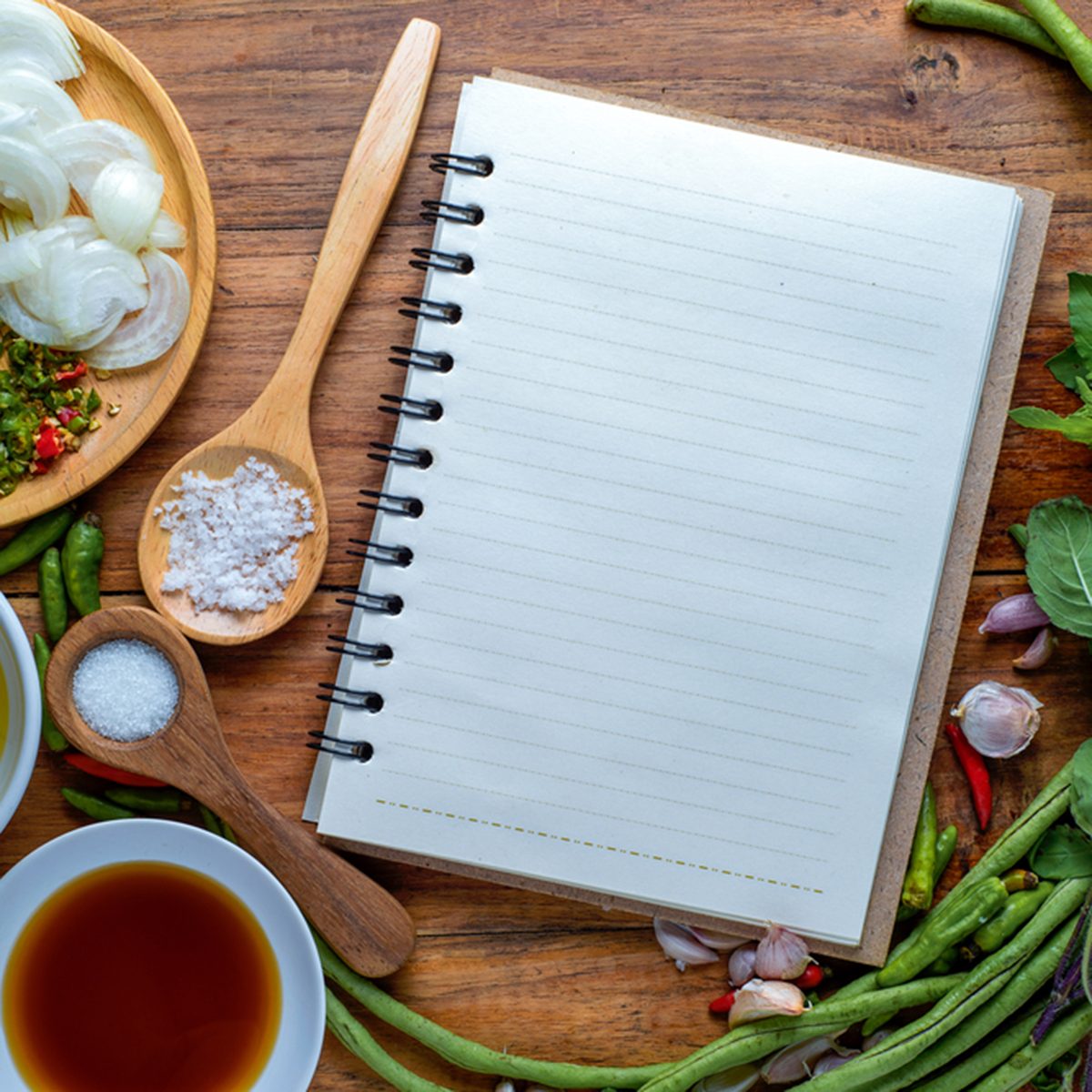 recipe book with fresh herbs south asia and spices on wooden background