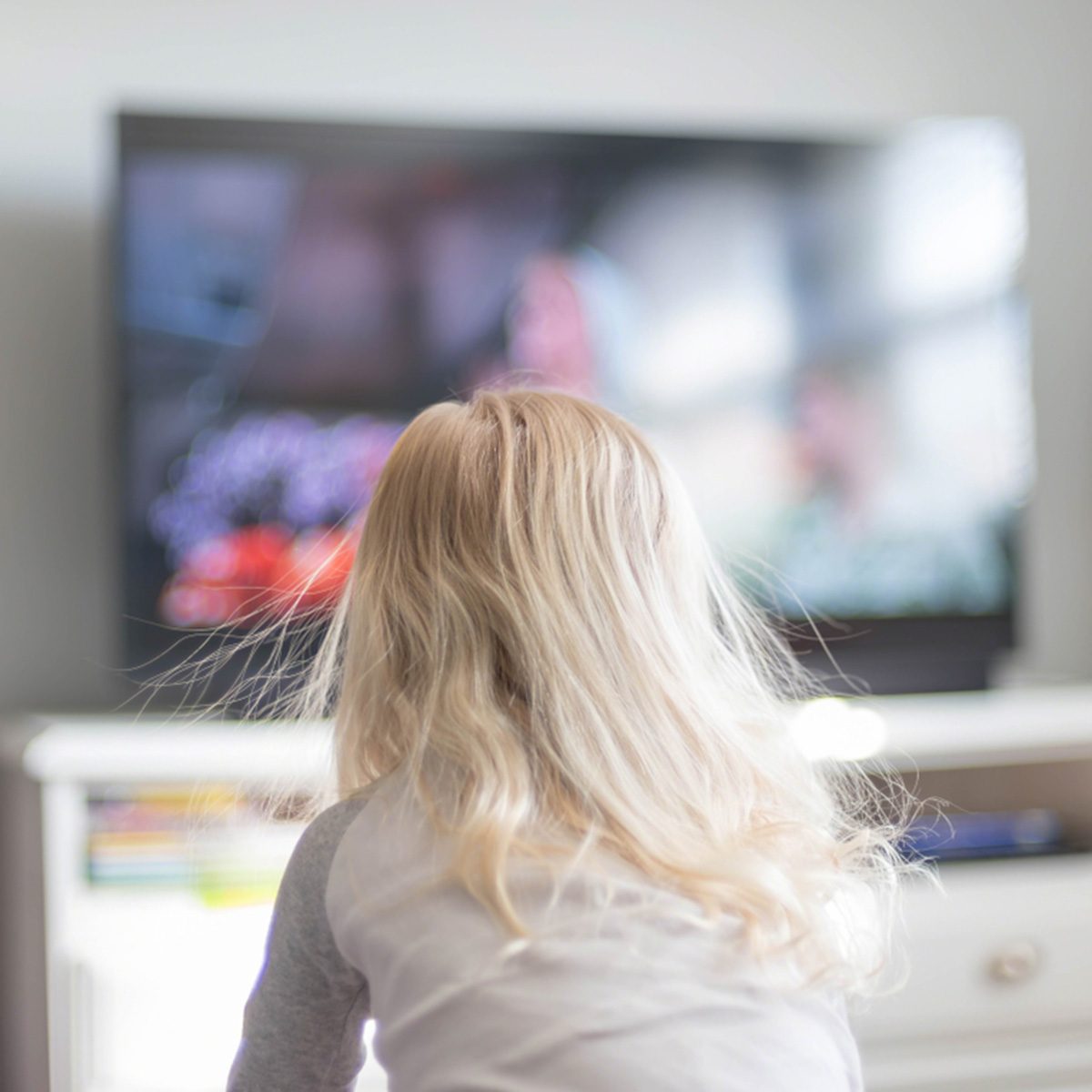 Blonde haired girl with static electricity watching TV in morning sunlight; Shutterstock ID 1043650873; Job (TFH, TOH, RD, BNB, CWM, CM): Taste of Home
