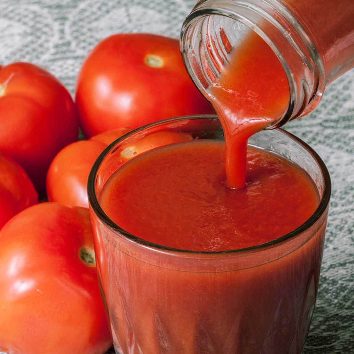 tomato juice with tomatoes on background