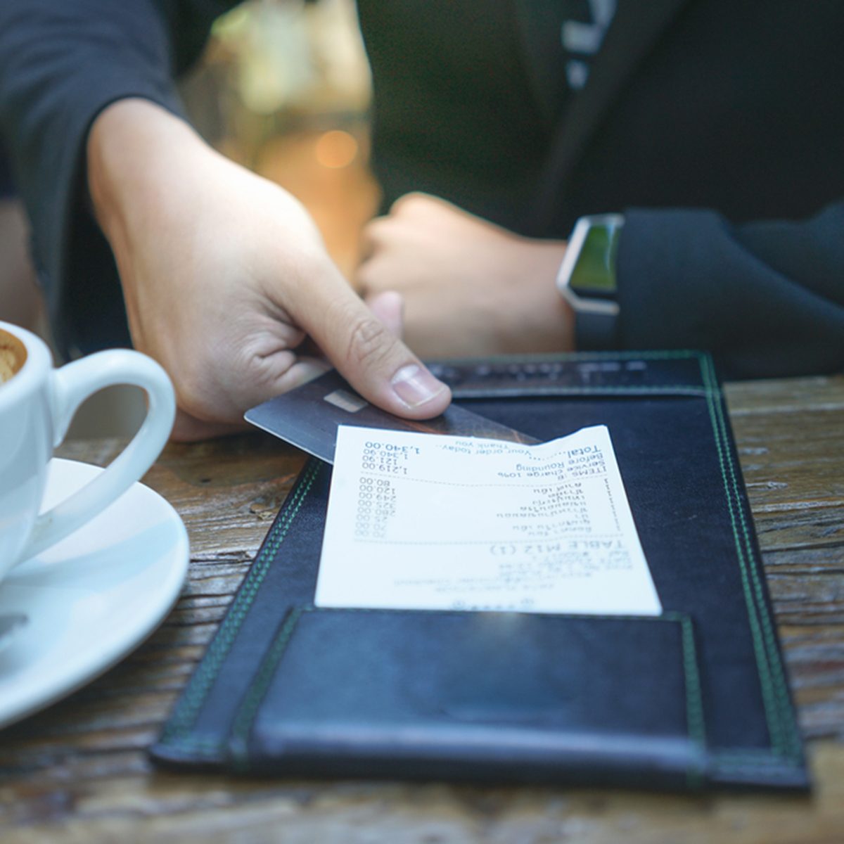 A businessman is paying his bill by credit card at the restaurant.