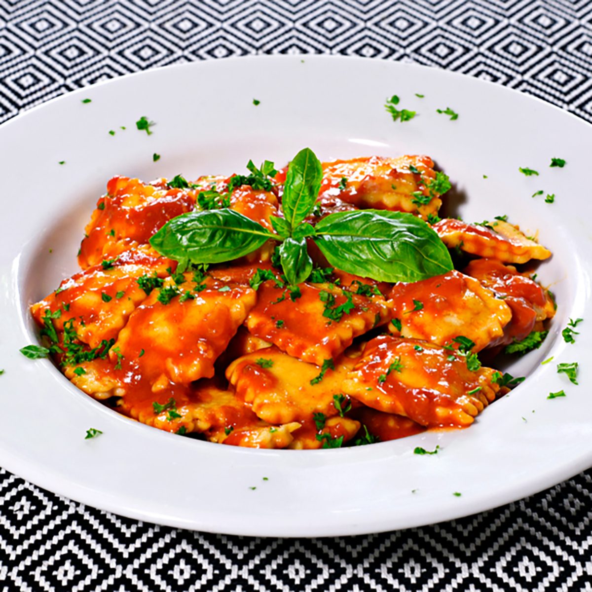 Fresh ravioli pasta with parsley and basil leaf, italian cuisine. 