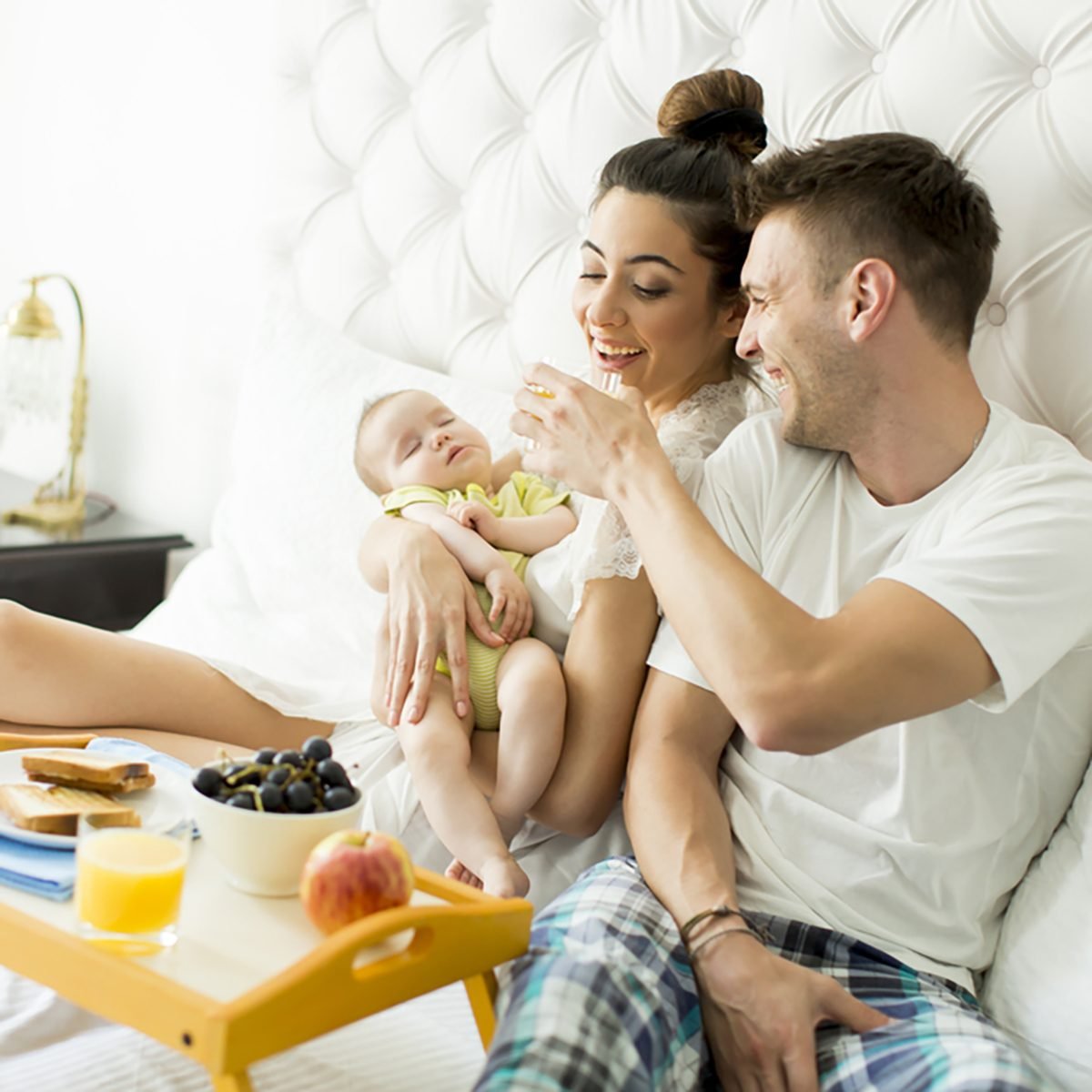 Mother, father and a baby together on the bed