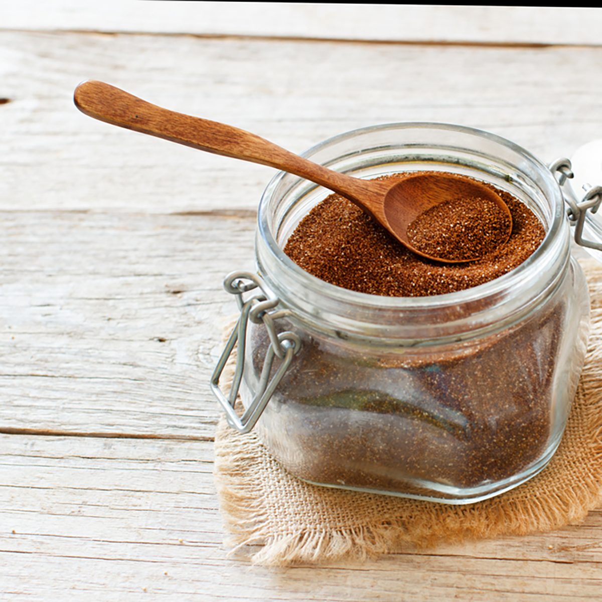 Uncooked teff grain in a glass jar with a spoon