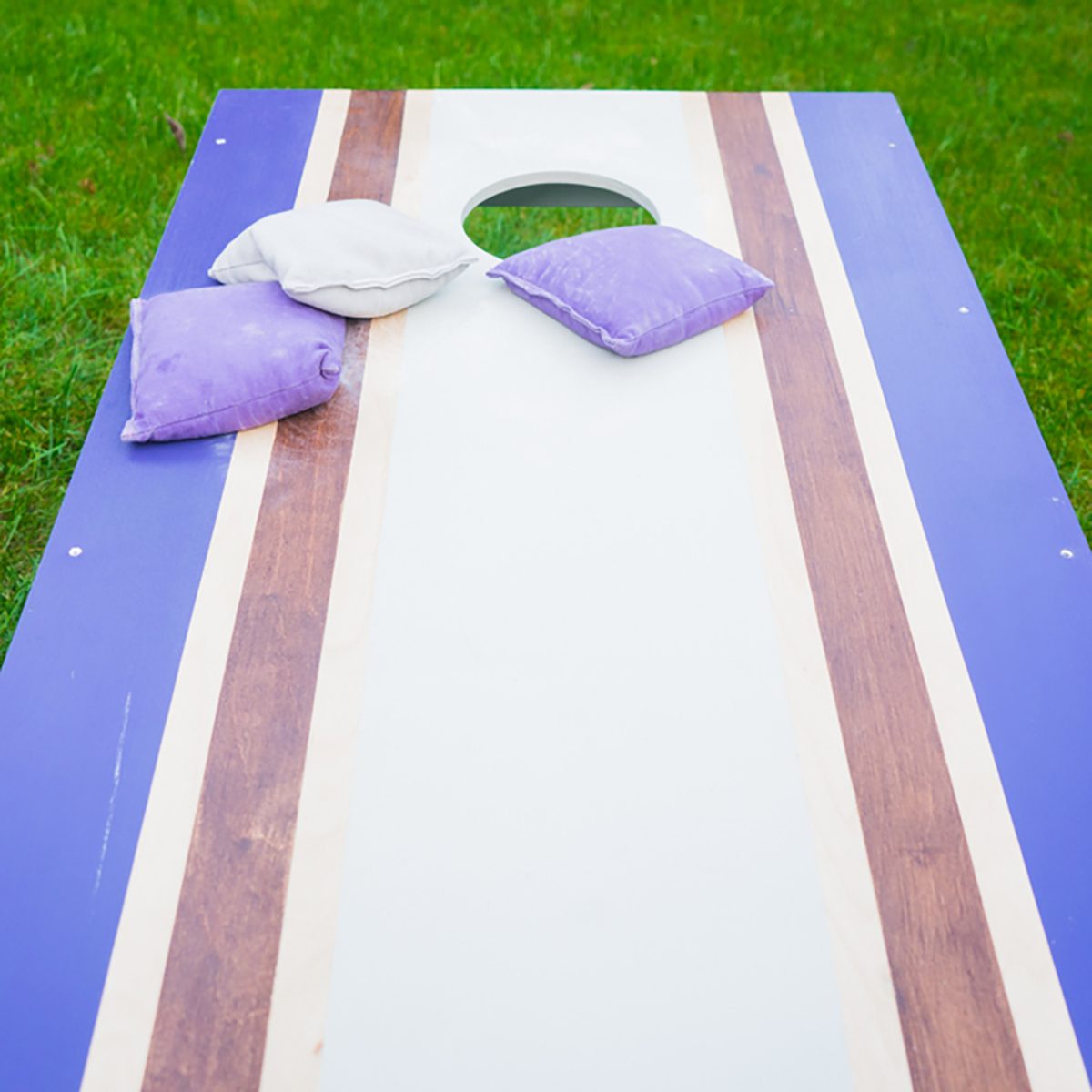 Cornhole bean bag toss wood game board outside on grass