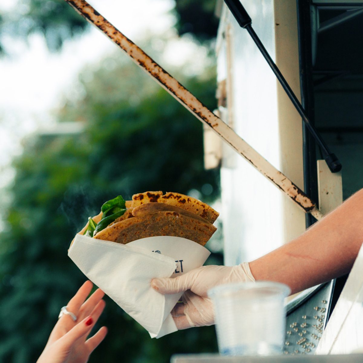 Food Truck salesperson reaches food for a client