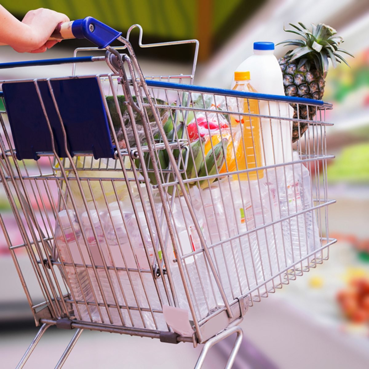 woman pushing shopping cart in supermarket
