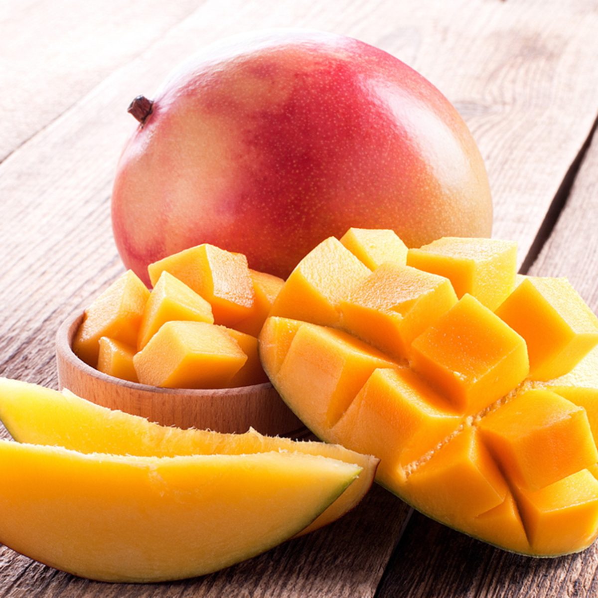 mango and mango slices on a wooden table