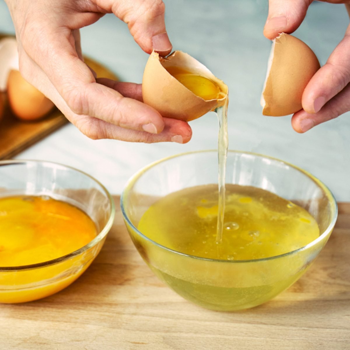 Woman breaks eggs and separates a protein from a yolk