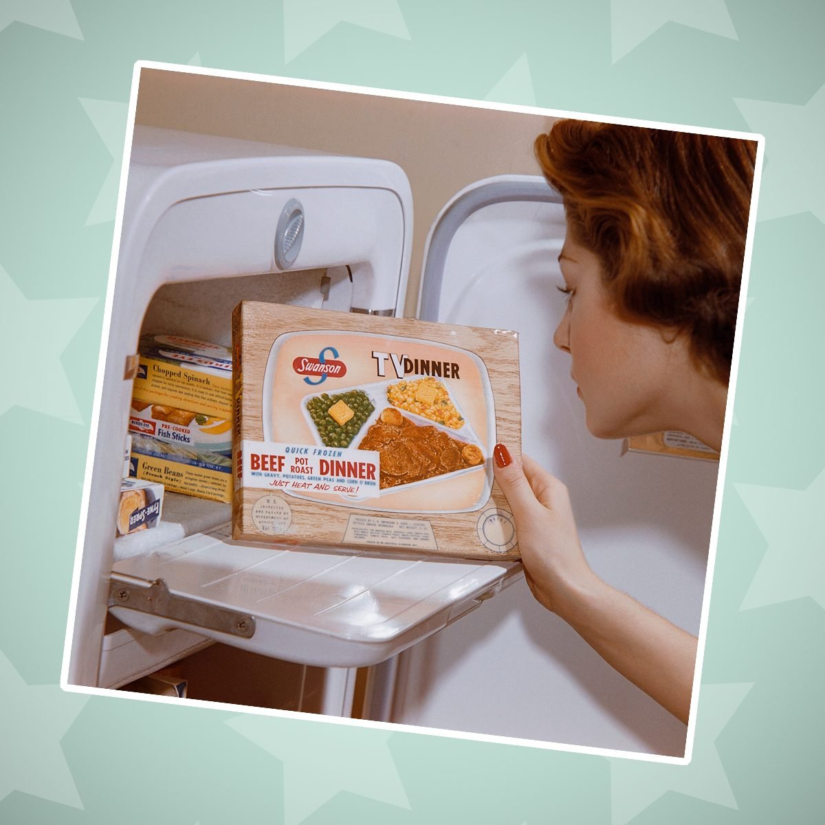 A woman examines a TV dinner box she has taken from the freezer