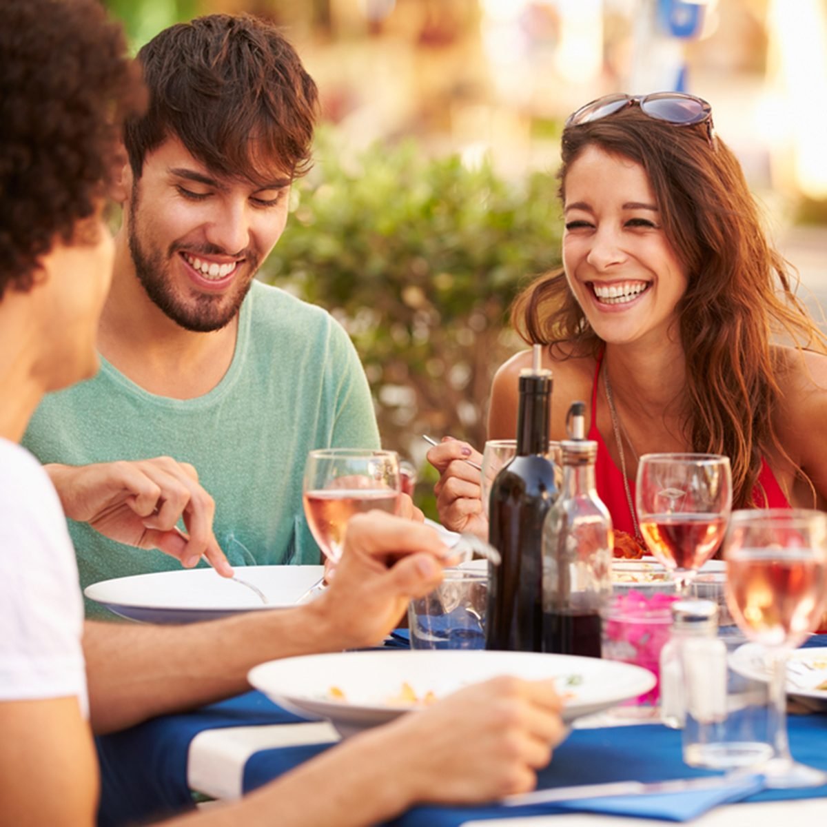 Group Of Young Friends Enjoying Meal In Outdoor Restaurant