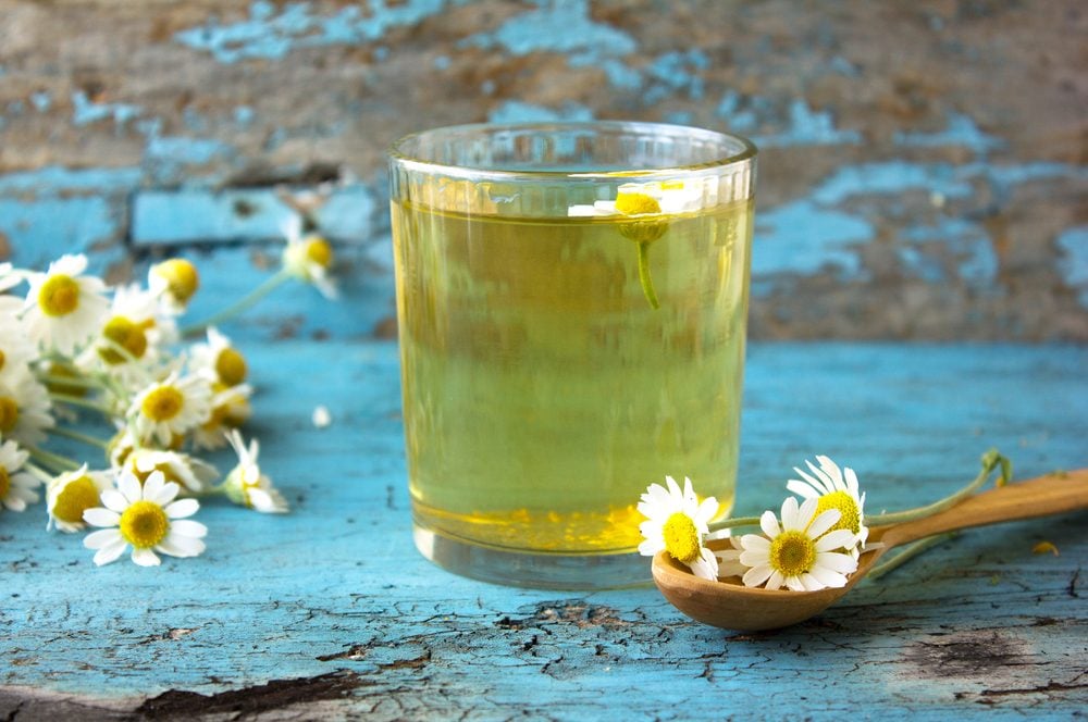 chamomile tea with flowers blue background