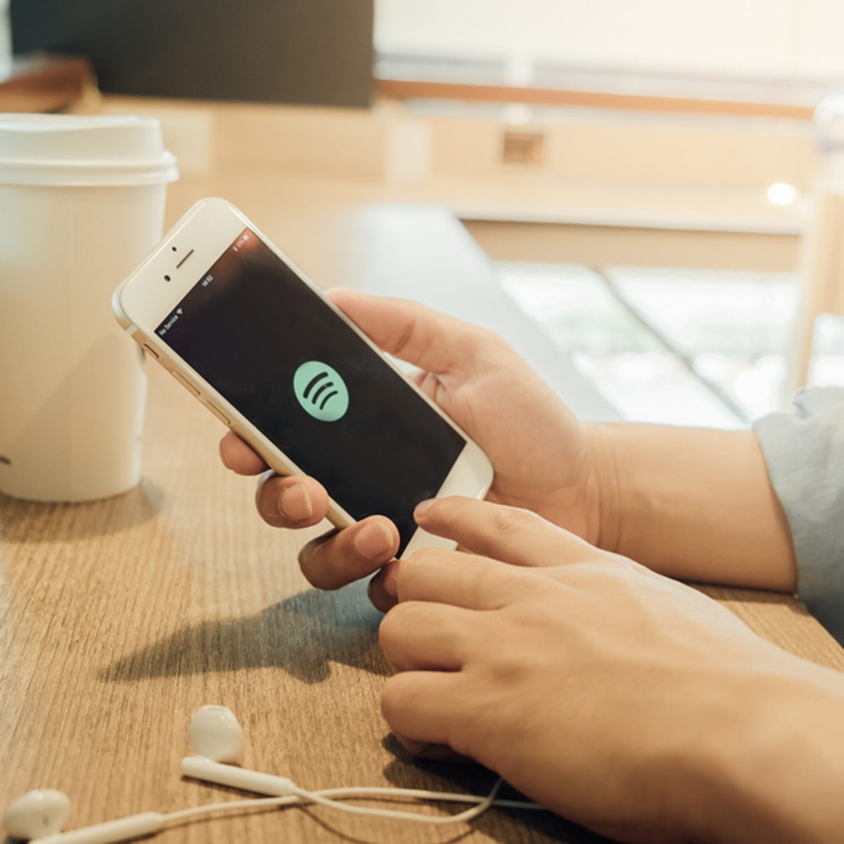 A man holding a iPhone 6 opening spotify app