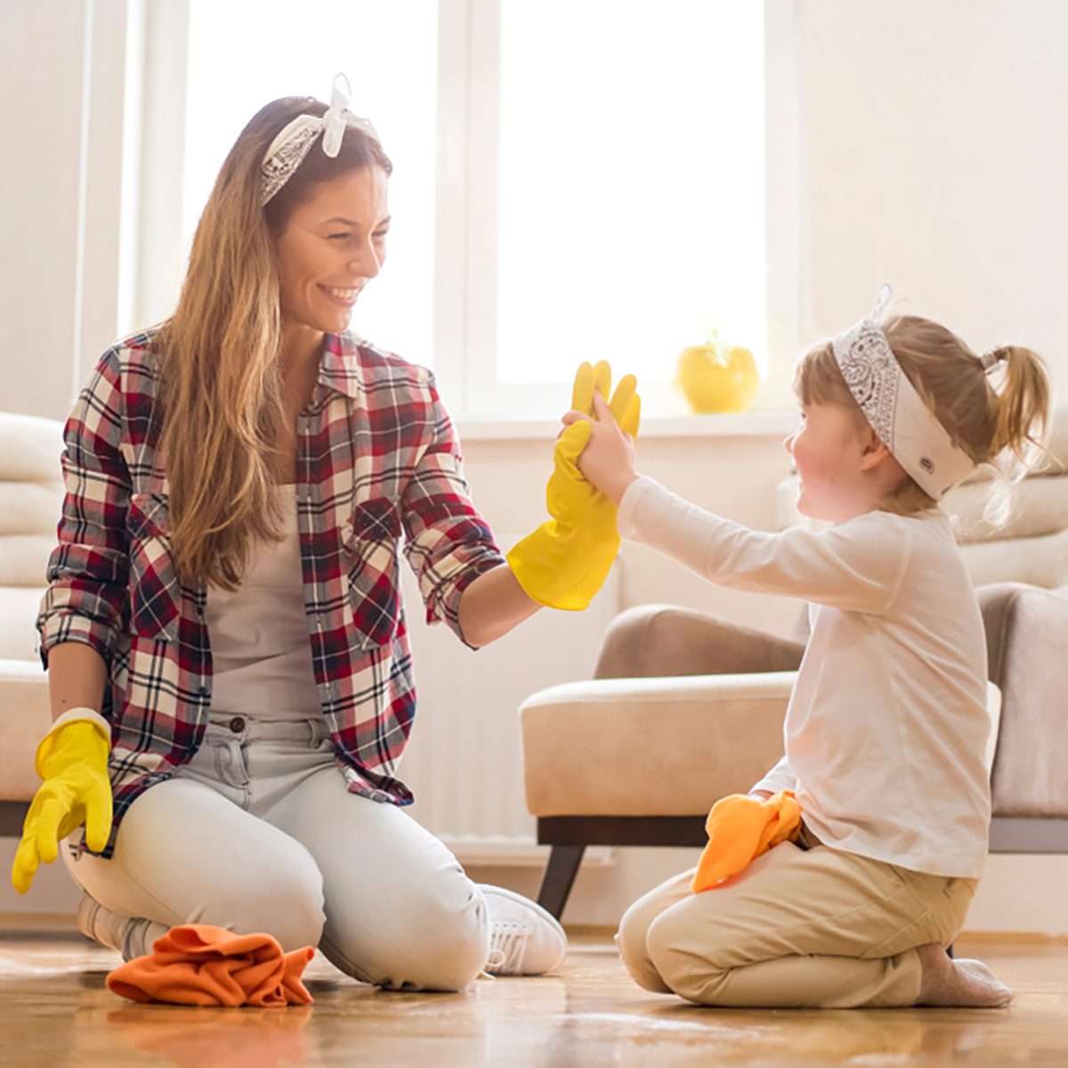 Daughter and mother cleaning home together and having fun