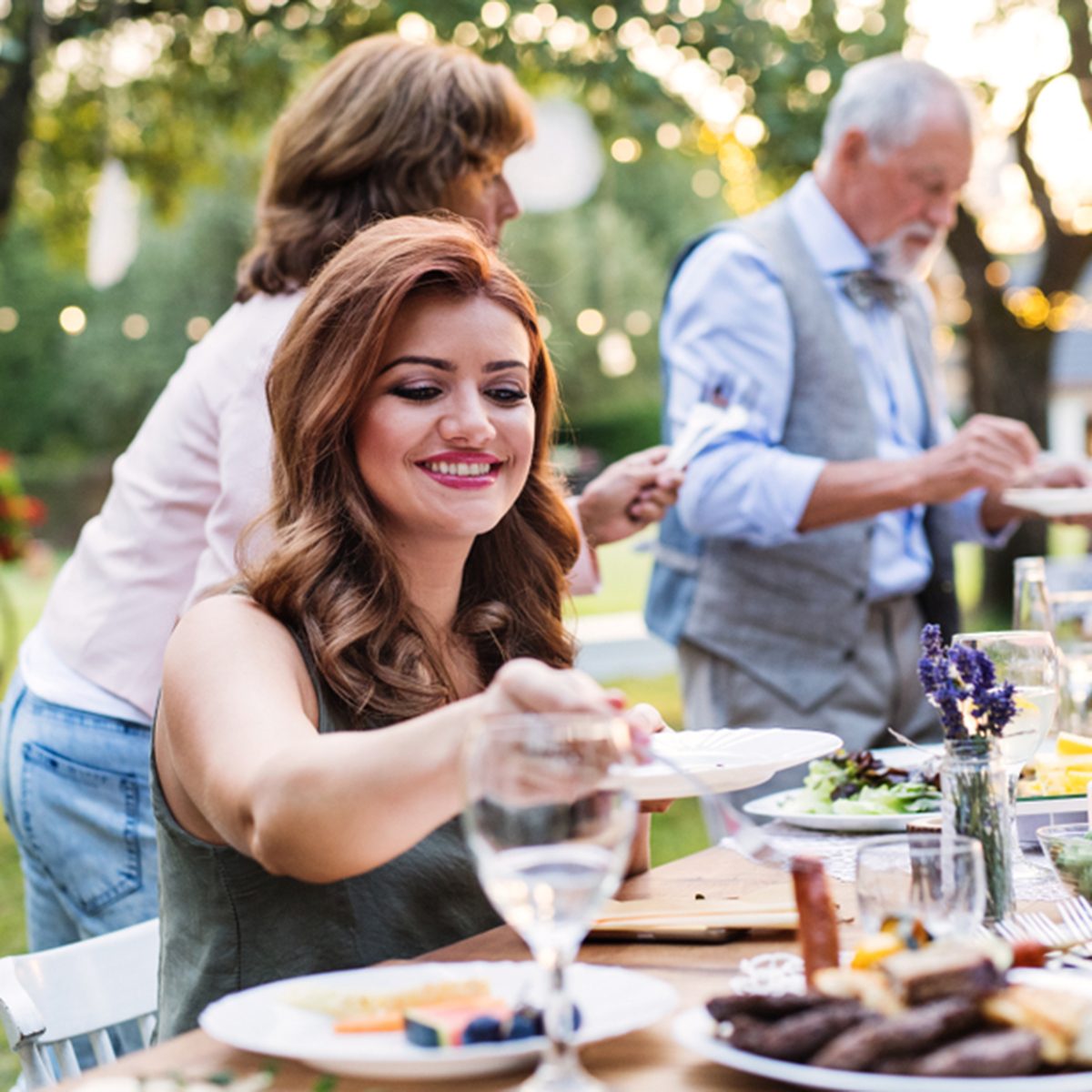 Guests eating at the wedding reception outside in the backyard.