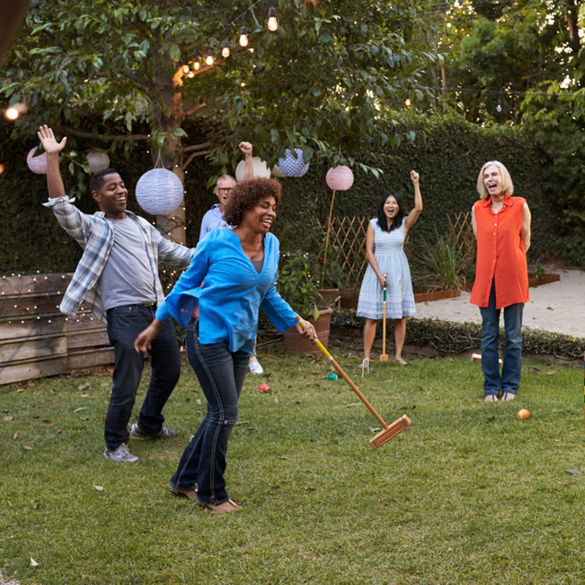 Group Of Mature Friends Playing Croquet In Backyard Together