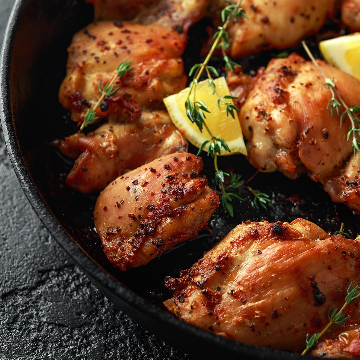 Roasted boneless skinless chicken thighs in lemon and thyme dressing served in vintage cast iron skillet