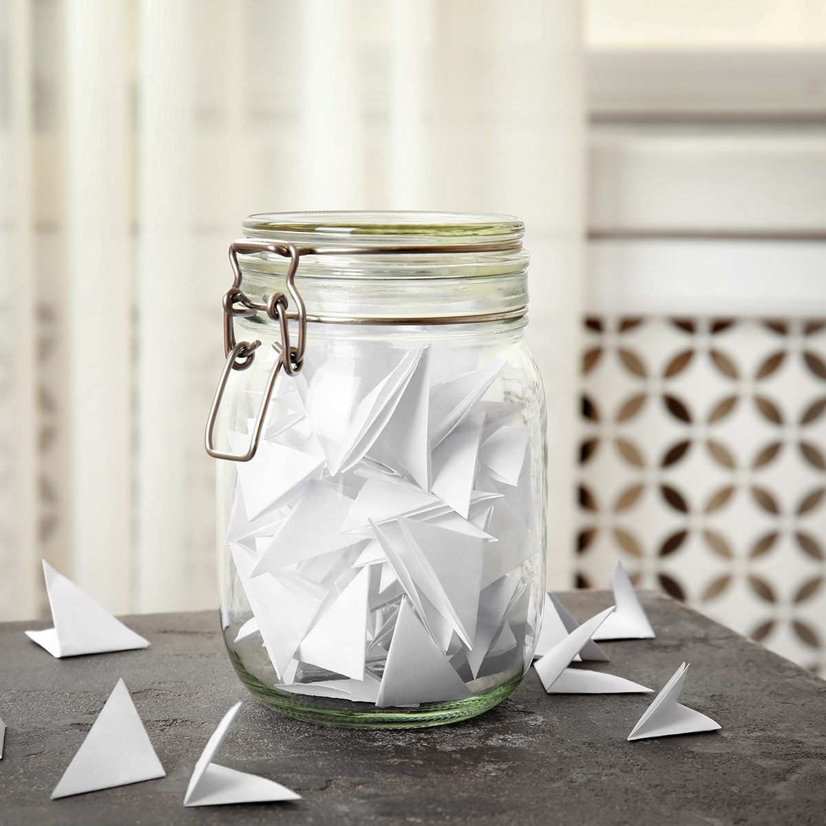 Paper pieces for lottery and glass jar on gray table