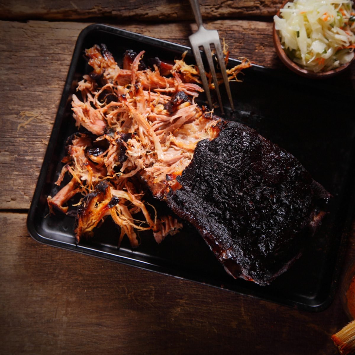 Aerial Shot of Mouth Watering Pulled Pork Dish on Black Serving Tray with Fork.