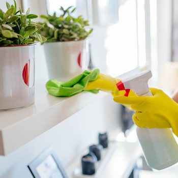 Woman wearing yellow rubber protective gloves and cleaning white shelf.; Shutterstock ID 546648745; Job (TFH, TOH, RD, BNB, CWM, CM): Taste of Home