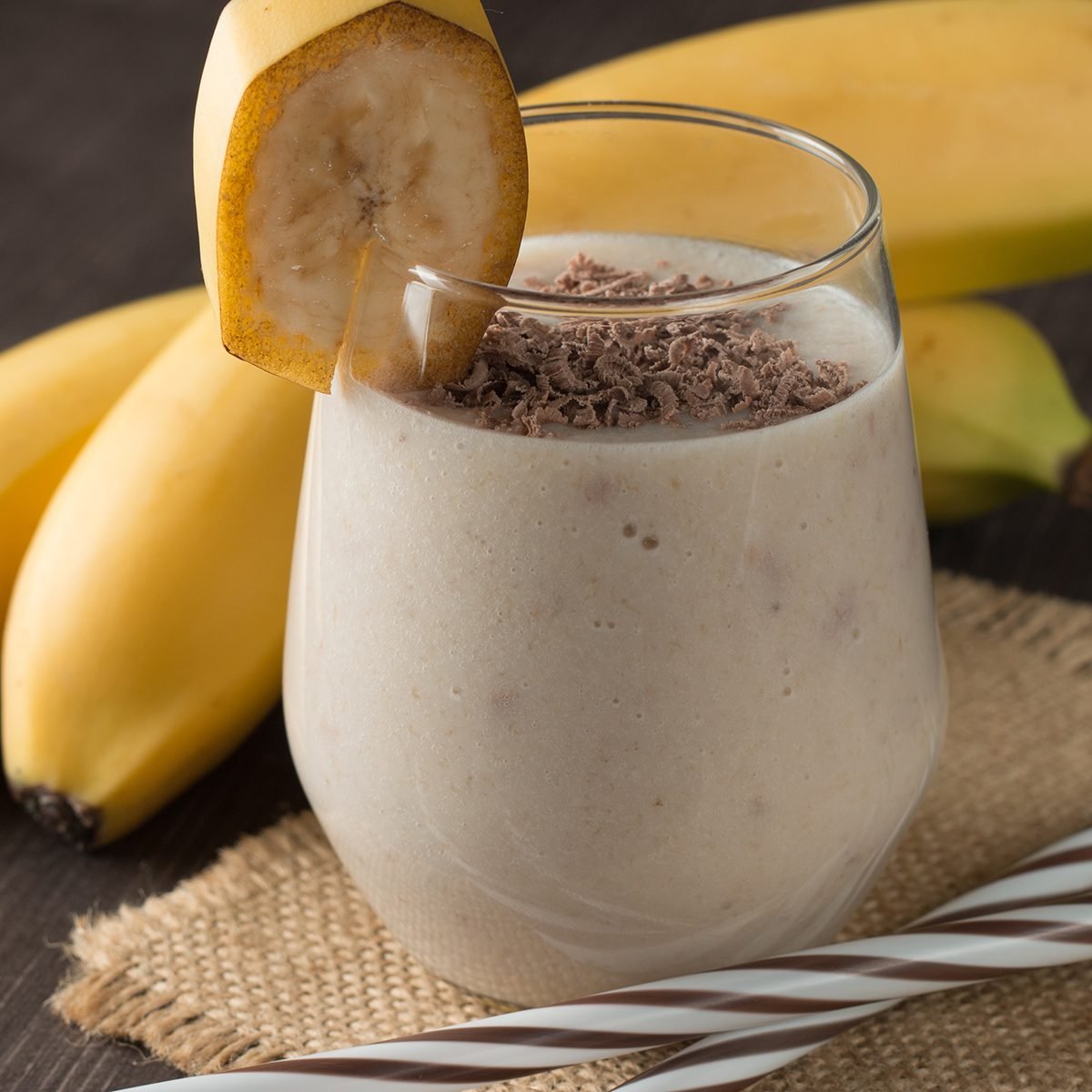 Photo of fresh Made Chocolate Banana Smoothie on a wooden table with coffee and spices.