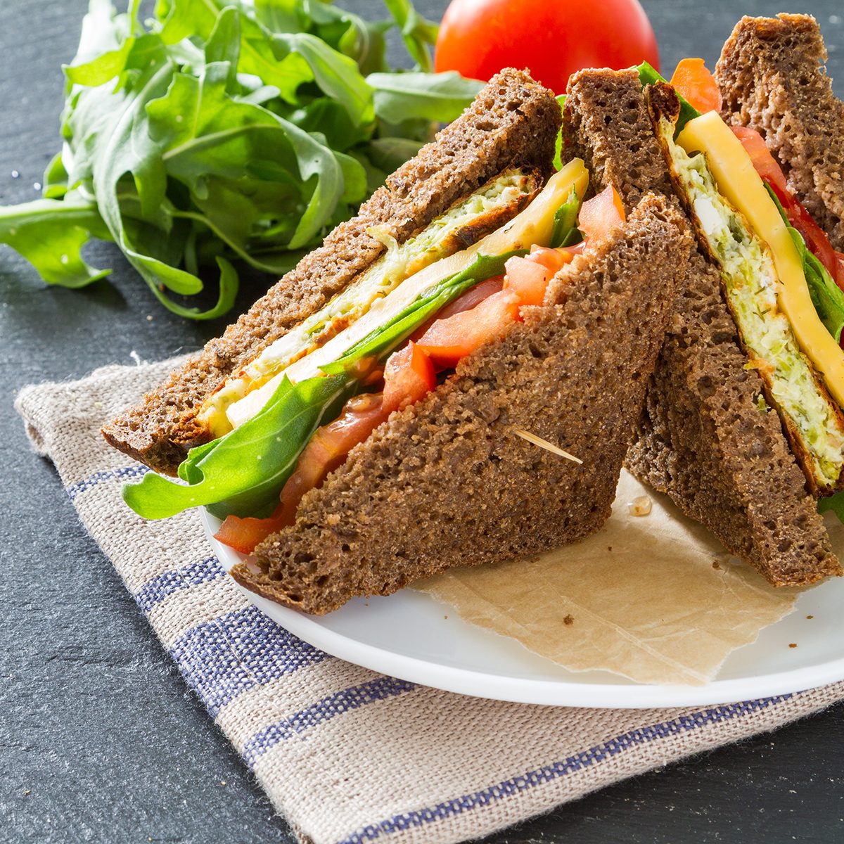 Vegetarian sandwich with zucchini burger, cheese, ruccola and tomatoes,