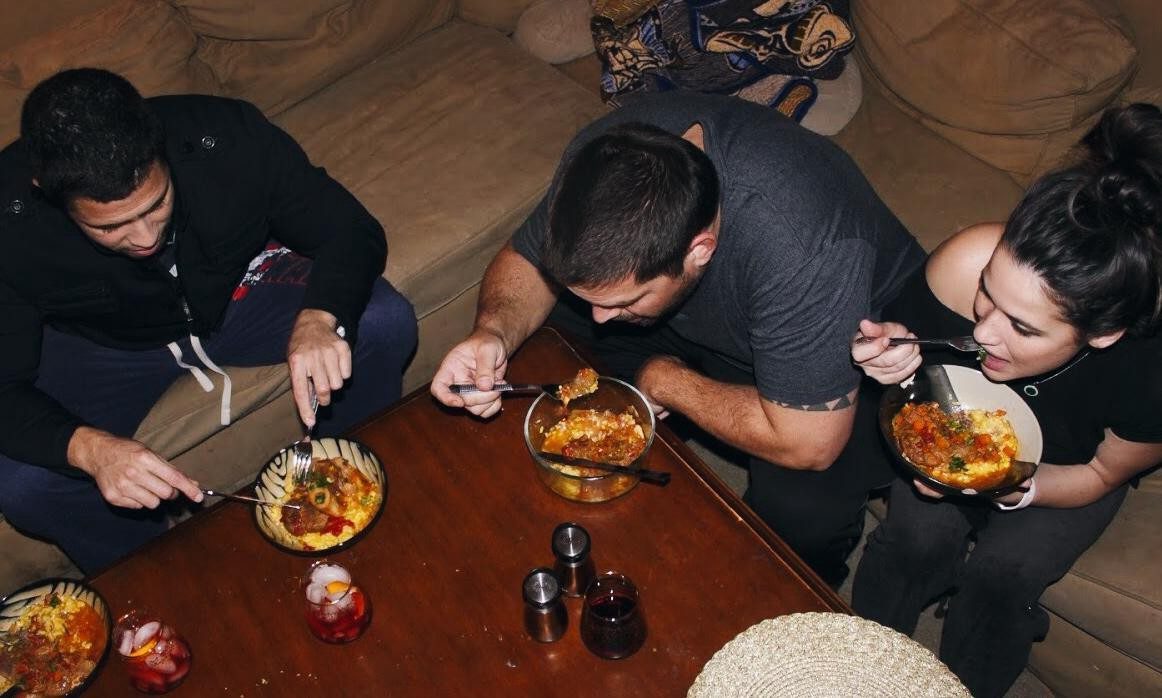 People around a table eating Osso Bucco with Saffron Risotto