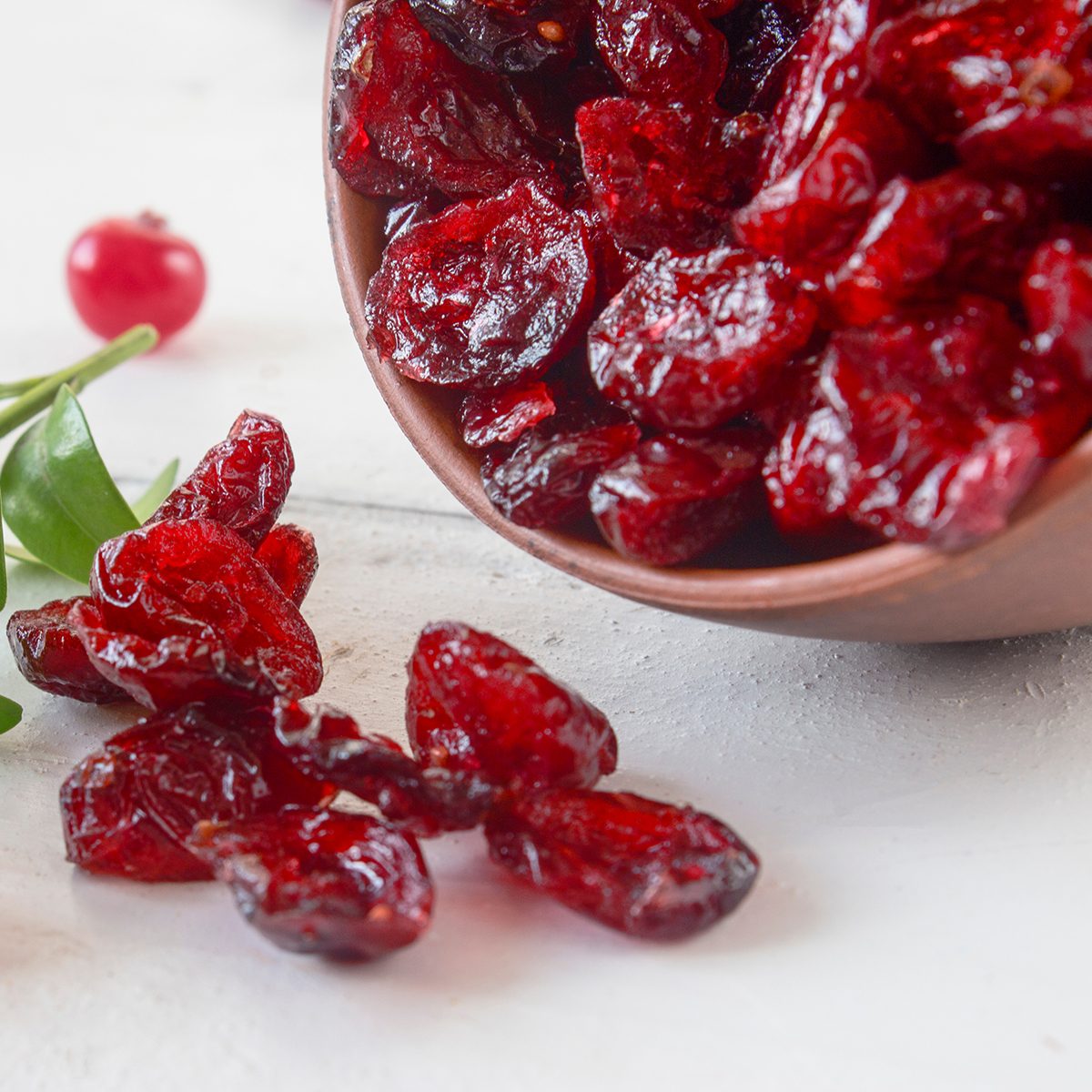 scattered on the table, a small pile of dried, useful red forest berries of cranberries