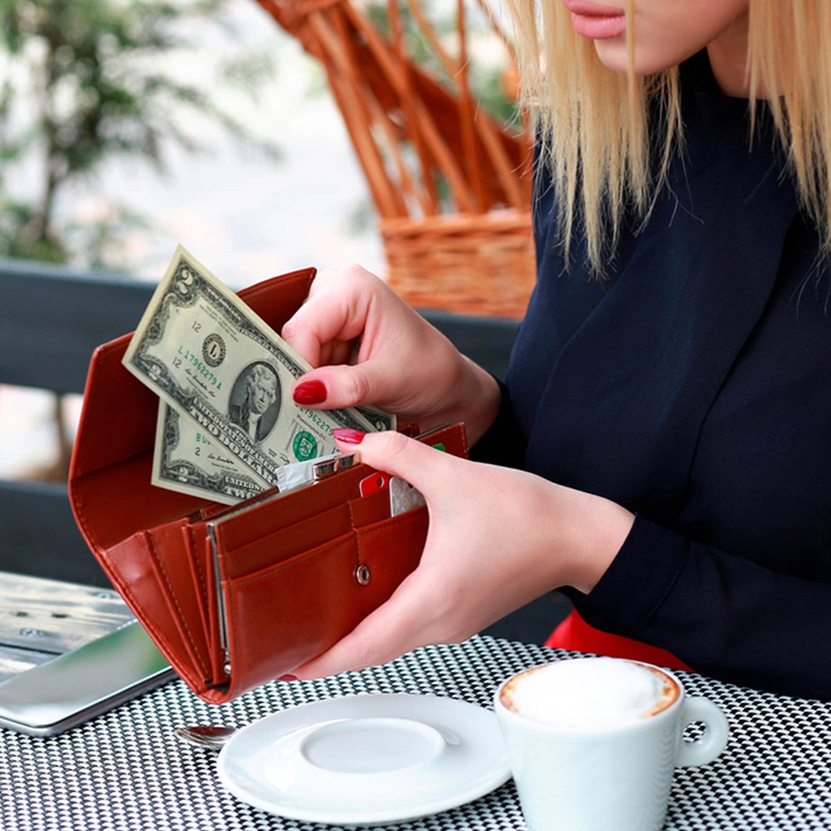 Woman pulling money out of her wallet at a coffee shop