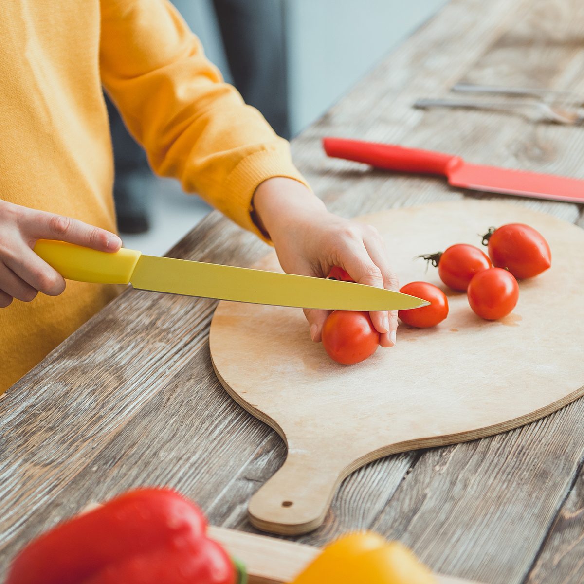 Close up of boy hands slicing vegetables for salad on cooking board; Shutterstock ID 1085667902; Job (TFH, TOH, RD, BNB, CWM, CM): Taste of Home