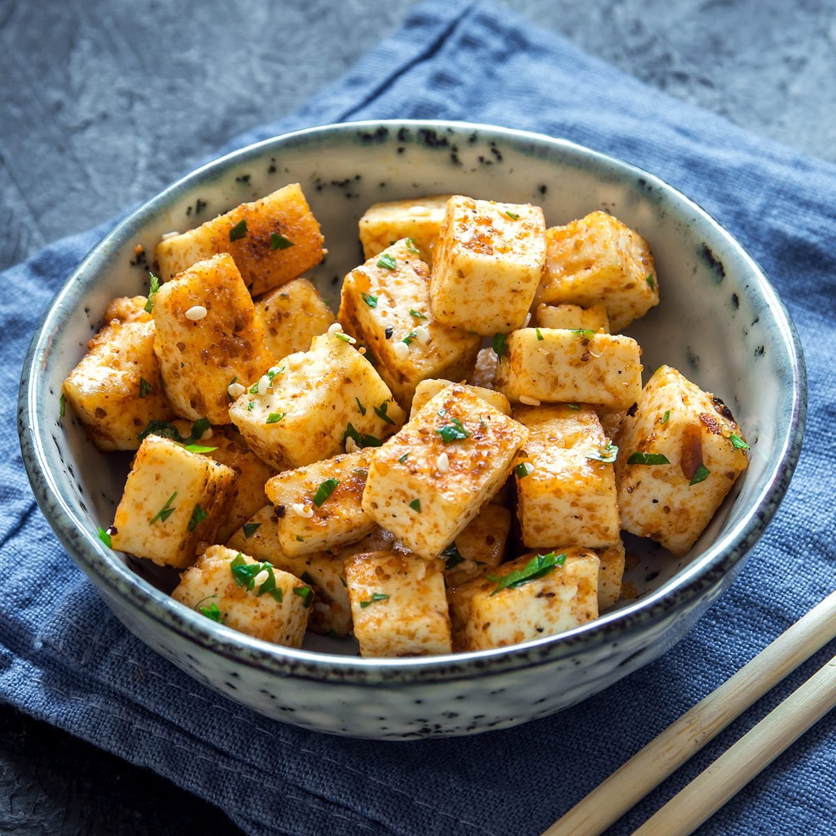 Stir Fried Tofu in a bowl with sesame and greens.